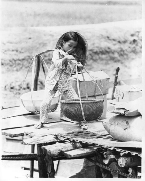 Child carrying salt from salt pans and boats on the road from Long Hai village to Baria (Provincial Capital).